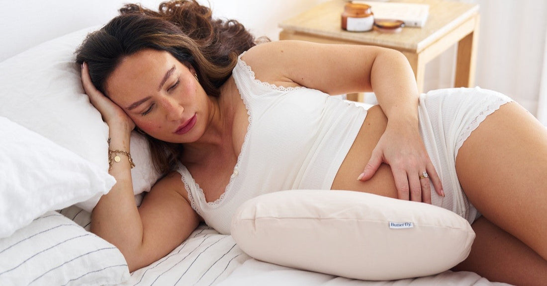 recovering post partum mum resting sleeping in bed supported by pillows 